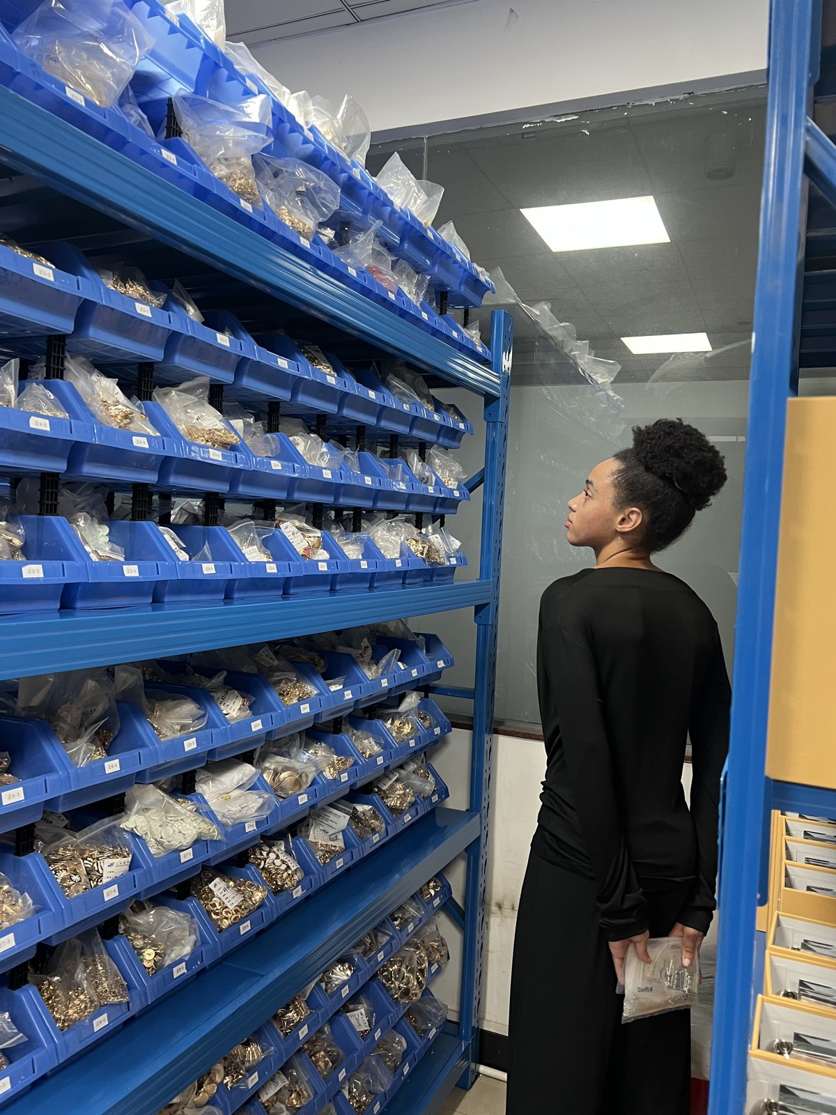 Exploring shelves of garment accessory samples at SANYE.